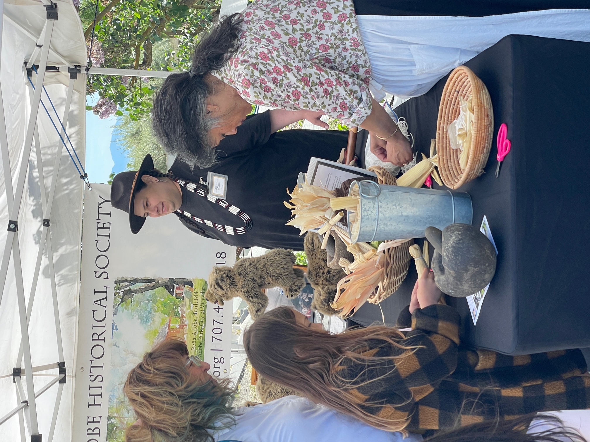 Peña Adobe Historical Society volunteers help young visitors make corn husk dolls at Rush Ranch's 33rd Annual Open House